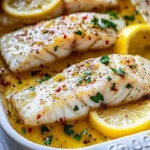 Baked lemon garlic cod filets drizzled with butter sauce on a plate