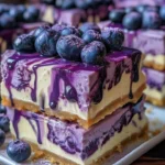 Delicious Blueberry Cheesecake Bars drizzled with blueberry sauce