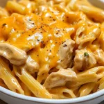 Plate of creamy Honey BBQ Chicken and cheddar pasta garnished with herbs