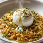 Creamy orzo risotto with lemon feta sauce and burrata core served in a bowl.