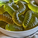 Dill pickle gummy worms candy in a colorful assortment.