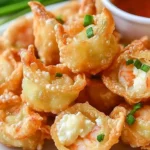 Crispy shrimp wontons filled with cream cheese served on a plate